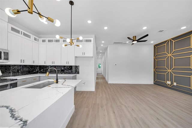 4902 Higgins St B, Unit A, Houston, TX 77033 - kitchen with a sink, stainless steel appliances, light wood finished floors, a chandelier, and backsplash