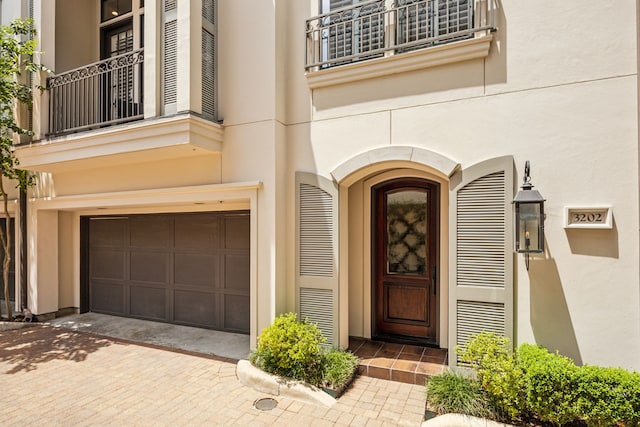 3202 Mid Ln, Houston, TX 77027 - view of exterior entry with a balcony, stucco siding, and a garage