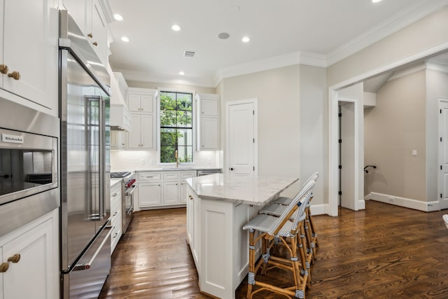 3202 Mid Ln, Houston, TX 77027 - kitchen featuring built in appliances, crown molding, recessed lighting, a center island, and white cabinetry