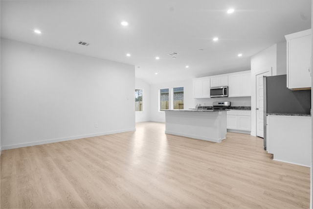405 Amy St, Angleton, TX 77515 - kitchen featuring appliances with stainless steel finishes, recessed lighting, open floor plan, white cabinets, and light wood-style flooring