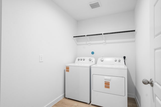 405 Amy St, Angleton, TX 77515 - laundry area featuring washer and clothes dryer, light wood-style flooring, and baseboards