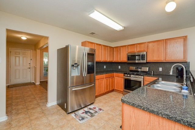 3434 Zephyr Glen Way, Houston, TX 77084 - kitchen featuring stainless steel appliances, a sink, dark countertops, tasteful backsplash, and baseboards