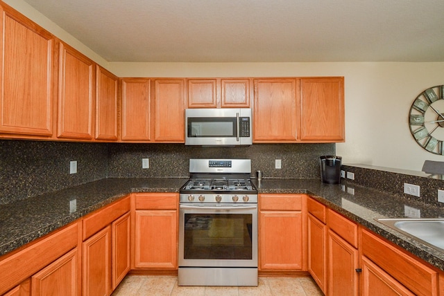3434 Zephyr Glen Way, Houston, TX 77084 - kitchen with stainless steel appliances, backsplash, dark stone countertops, and a sink