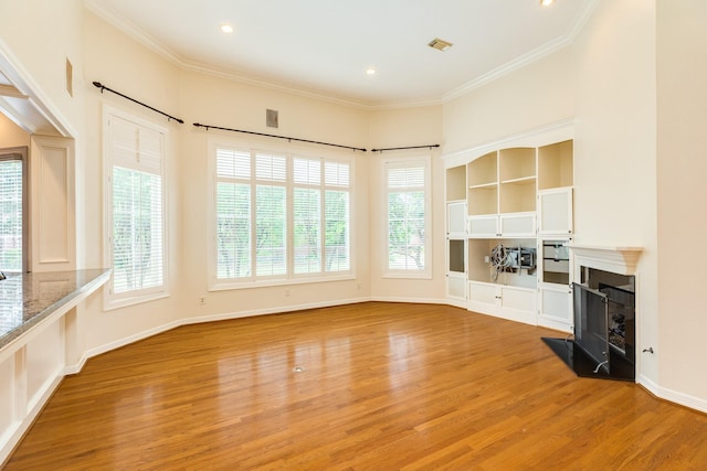 1 Heritage Oak Ct, Lake Jackson, TX 77566 - unfurnished living room featuring light wood finished floors, a fireplace with raised hearth, ornamental molding, recessed lighting, and baseboards