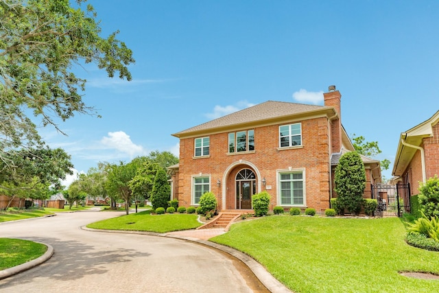 1 Heritage Oak Ct, Lake Jackson, TX 77566 - view of front of home featuring a chimney, brick siding, and a gate