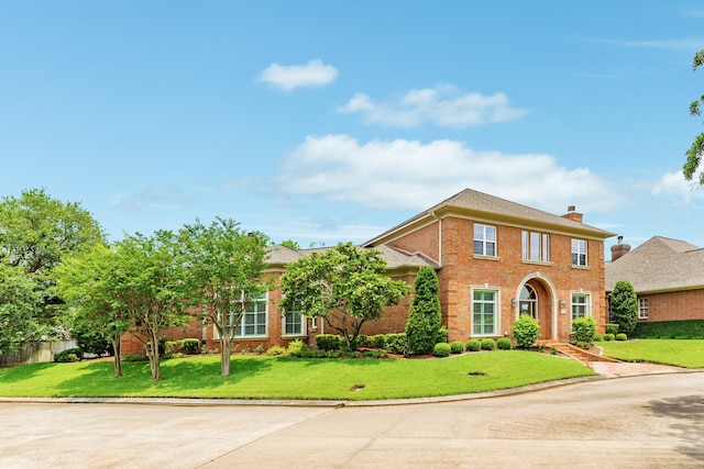 1 Heritage Oak Ct, Lake Jackson, TX 77566 - view of front facade featuring a front yard, brick siding, and a chimney