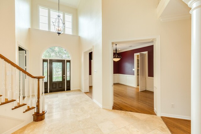 1 Heritage Oak Ct, Lake Jackson, TX 77566 - foyer entrance with crown molding, a high ceiling, stairway, tile patterned flooring, and ornate columns