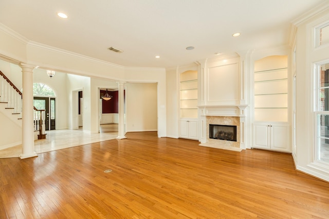 1 Heritage Oak Ct, Lake Jackson, TX 77566 - unfurnished living room with light wood-style flooring, decorative columns, a high end fireplace, crown molding, and stairway