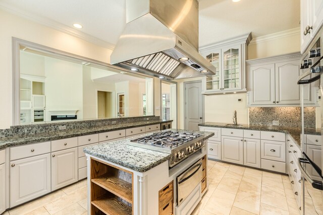 1 Heritage Oak Ct, Lake Jackson, TX 77566 - kitchen featuring island exhaust hood, crown molding, backsplash, a sink, and white cabinets