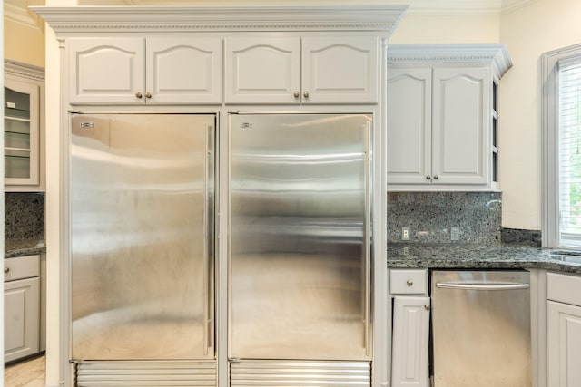 1 Heritage Oak Ct, Lake Jackson, TX 77566 - kitchen featuring appliances with stainless steel finishes, dark stone countertops, ornamental molding, backsplash, and glass insert cabinets