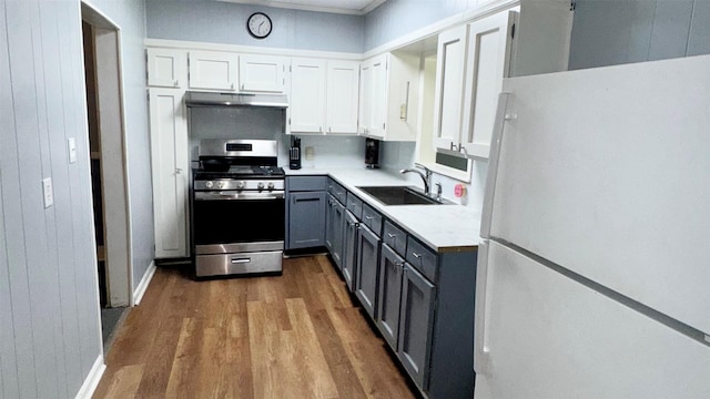1105 S Main St, Highlands, TX 77562 - kitchen featuring freestanding refrigerator, gas range, a sink, under cabinet range hood, and gray cabinetry