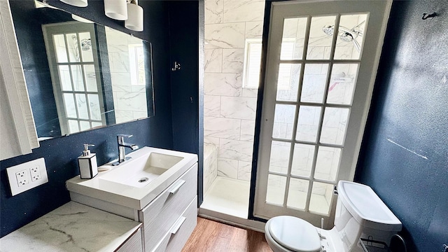 1105 S Main St, Highlands, TX 77562 - full bathroom featuring a stall shower, toilet, wood finished floors, a textured wall, and vanity