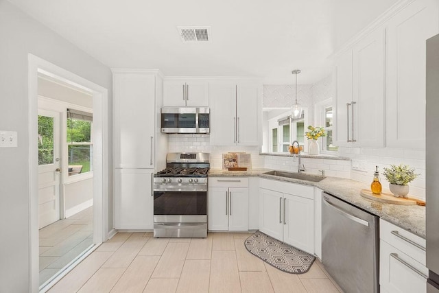 4502 Lido Ln, Houston, TX 77092 - kitchen with stainless steel appliances, a sink, tasteful backsplash, white cabinets, and light stone countertops