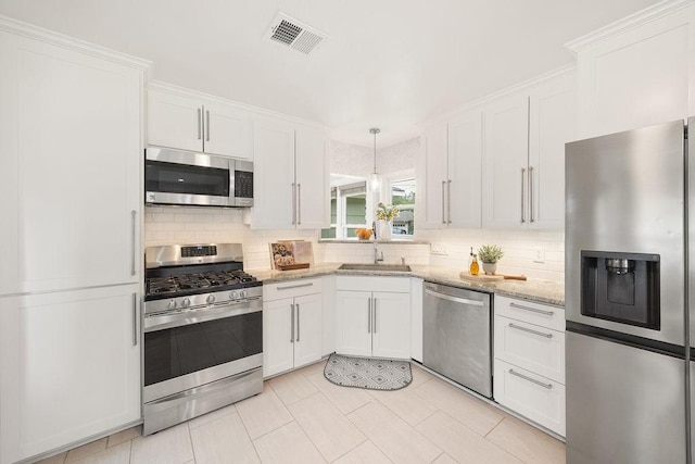 4502 Lido Ln, Houston, TX 77092 - kitchen featuring stainless steel appliances, a sink, white cabinetry, and tasteful backsplash