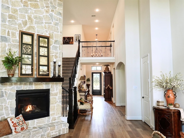 2038 Green Haven Ct, Missouri City, TX 77459 - living area featuring wood finished floors, stairs, arched walkways, baseboards, and a stone fireplace