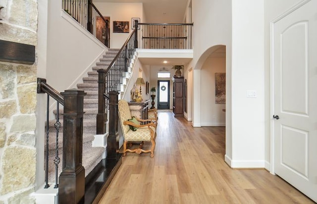2038 Green Haven Ct, Missouri City, TX 77459 - foyer featuring a towering ceiling, arched walkways, light wood finished floors, stairway, and baseboards