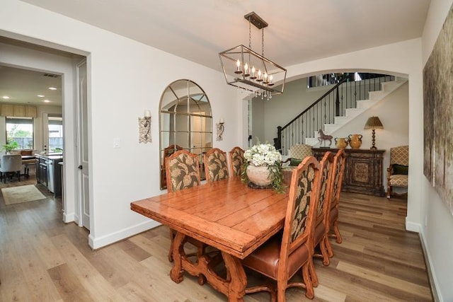 2038 Green Haven Ct, Missouri City, TX 77459 - dining area with a chandelier, light wood-style floors, stairs, recessed lighting, and baseboards