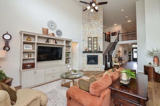 2038 Green Haven Ct, Missouri City, TX 77459 - living area with a high ceiling, wood finished floors, ceiling fan, stairs, and a fireplace