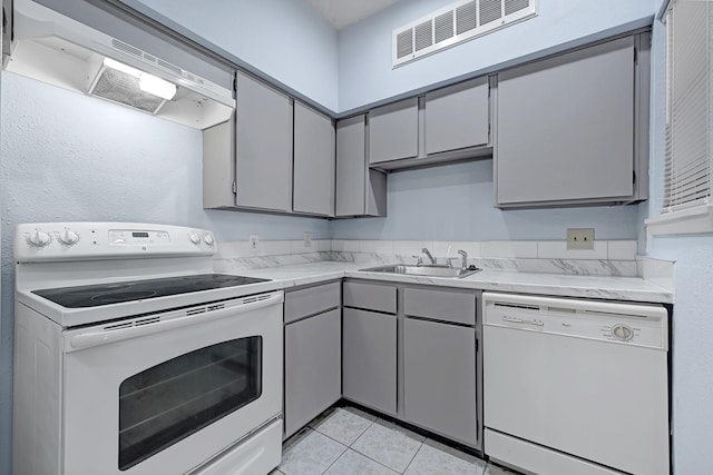 10855 Meadowglen Ln Unit 806, Houston, TX 77042 - kitchen featuring white appliances, a sink, under cabinet range hood, and gray cabinetry