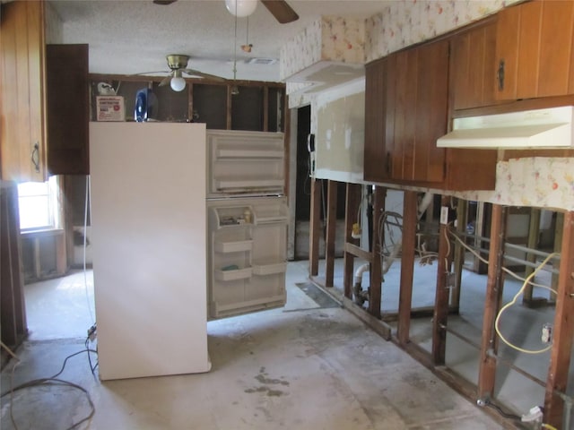 21315 Greengate Dr, Spring, TX 77388 - kitchen with ceiling fan, brown cabinets, under cabinet range hood, and freestanding refrigerator