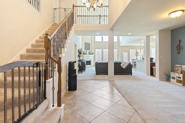 10518 Kicking Horse Pass, Cypress, TX 77433 - foyer with carpet, a chandelier, stairway, a towering ceiling, and tile patterned floors