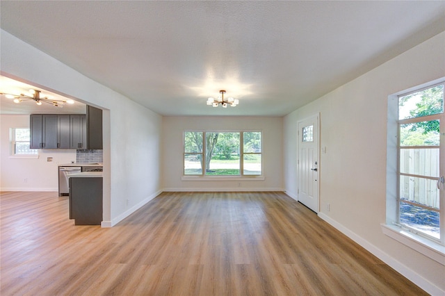 4914 Pershing St, Houston, TX 77033 - unfurnished living room featuring a chandelier, light wood finished floors, and baseboards