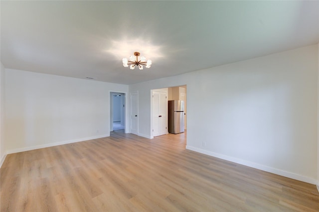 4914 Pershing St, Houston, TX 77033 - empty room with a chandelier, light wood-type flooring, and baseboards
