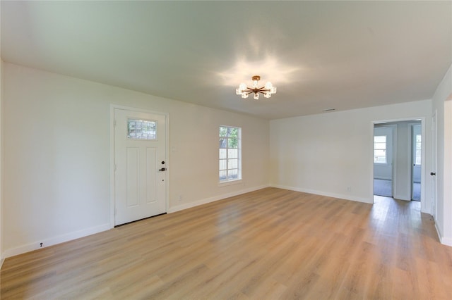 4914 Pershing St, Houston, TX 77033 - unfurnished living room with a chandelier, light wood-style flooring, and baseboards