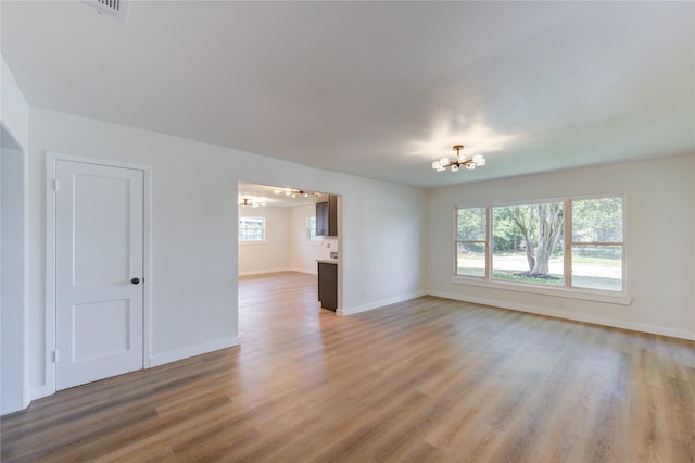 4914 Pershing St, Houston, TX 77033 - empty room featuring a chandelier, light wood-type flooring, and baseboards