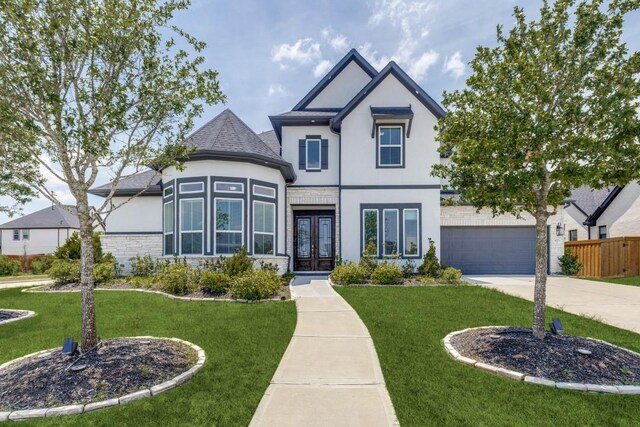 14303 Paseo Marbella Dr, Cypress, TX 77433 - view of front of house with french doors, stucco siding, driveway, stone siding, and a garage