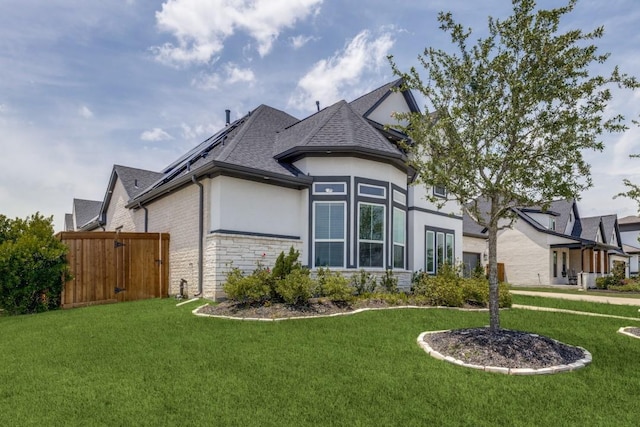 14303 Paseo Marbella Dr, Cypress, TX 77433 - view of front of house featuring stone siding, stucco siding, roof with shingles, and roof mounted solar panels