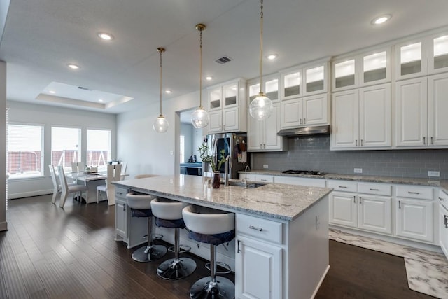 14303 Paseo Marbella Dr, Cypress, TX 77433 - kitchen featuring smart refrigerator, gas cooktop, under cabinet range hood, an island with sink, and dark wood-style floors