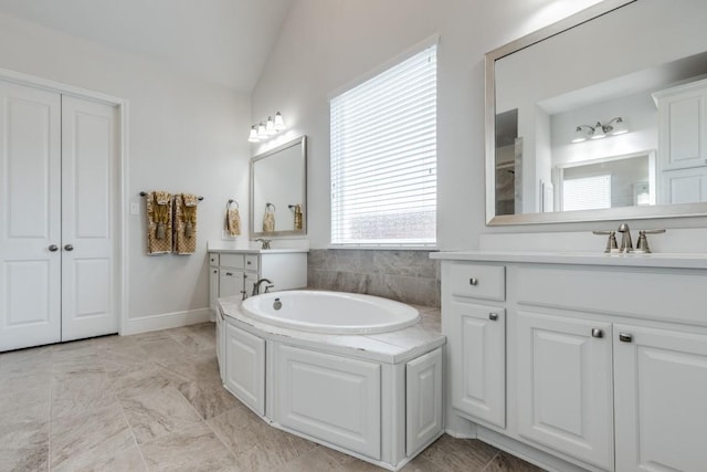 14303 Paseo Marbella Dr, Cypress, TX 77433 - bathroom featuring vaulted ceiling, a garden tub, marble look tiles, and two vanities