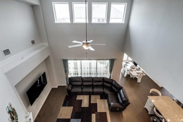 14303 Paseo Marbella Dr, Cypress, TX 77433 - living room featuring dark wood-type flooring, a high ceiling, ceiling fan, and a fireplace with raised hearth