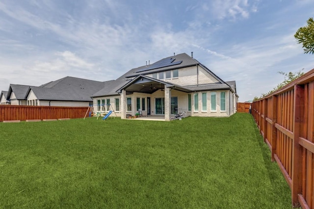 14303 Paseo Marbella Dr, Cypress, TX 77433 - back of house featuring roof mounted solar panels, a patio, and a playground