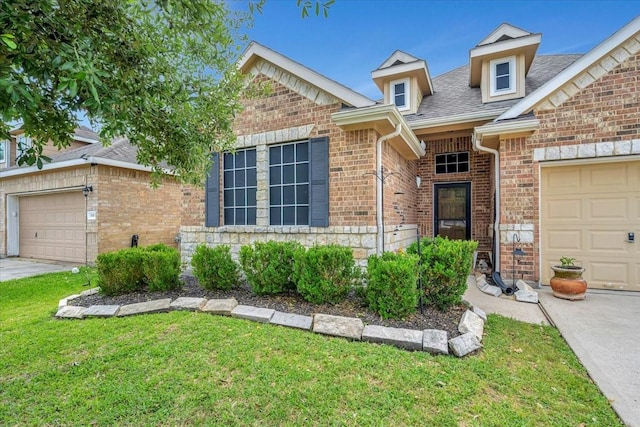 8323 Egret Bay Cir, Baytown, TX 77523 - view of front of home featuring an attached garage, brick siding, a front lawn, roof with shingles, and stone siding