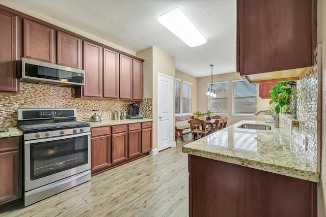 8323 Egret Bay Cir, Baytown, TX 77523 - kitchen featuring stainless steel appliances, a sink, tasteful backsplash, light wood-type flooring, and light stone countertops