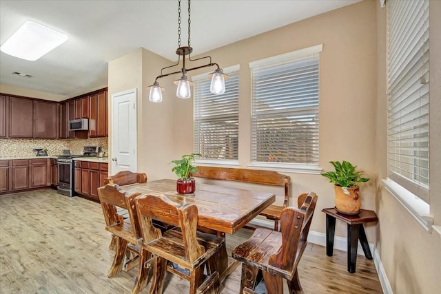 8323 Egret Bay Cir, Baytown, TX 77523 - dining room featuring light wood-style floors, plenty of natural light, and baseboards