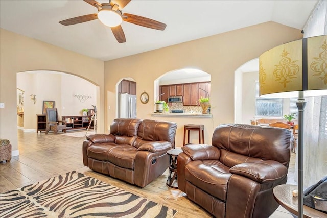 8323 Egret Bay Cir, Baytown, TX 77523 - living room with arched walkways, a ceiling fan, light wood-style floors, and lofted ceiling