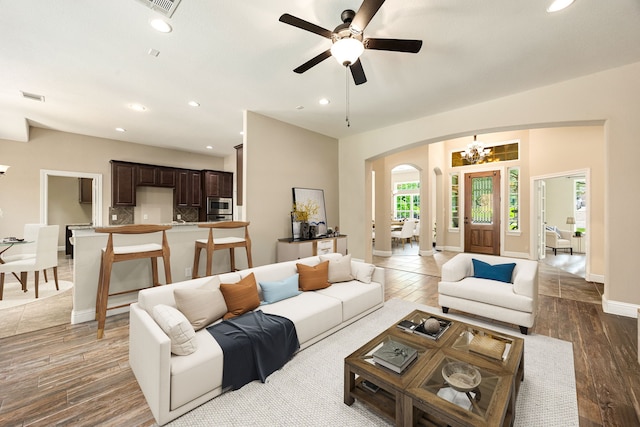 42 Brookefield Cir, Magnolia, TX 77355 - living room featuring arched walkways, recessed lighting, baseboards, a ceiling fan, and a chandelier