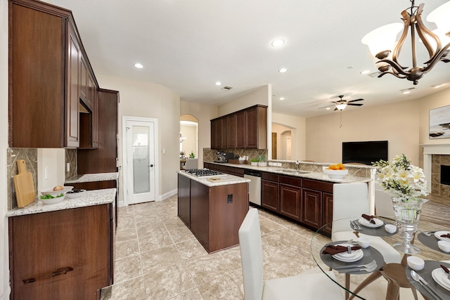 42 Brookefield Cir, Magnolia, TX 77355 - kitchen featuring arched walkways, stainless steel appliances, tasteful backsplash, a sink, and open floor plan