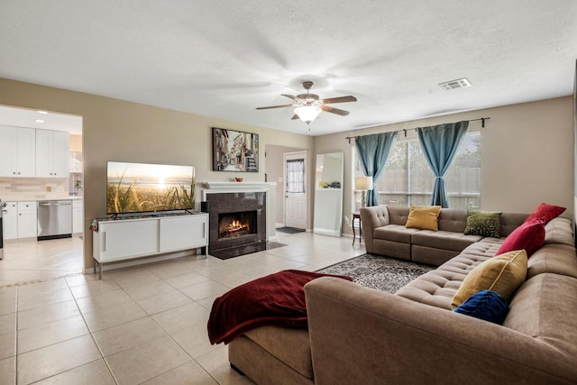 3315 Keygate Dr, Spring, TX 77388 - living room with light tile patterned flooring, healthy amount of natural light, ceiling fan, a textured ceiling, and a fireplace