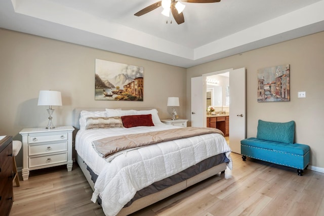 3315 Keygate Dr, Spring, TX 77388 - bedroom featuring wood finished floors, a tray ceiling, ensuite bathroom, and baseboards
