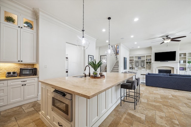 1249 Gardenia Dr, Houston, TX 77018 - kitchen featuring a sink, ornamental molding, ceiling fan, open floor plan, and stone tile floors