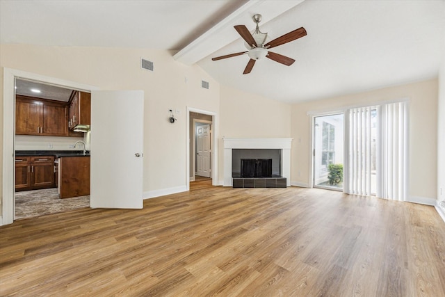 12124 Burdine St, Houston, TX 77035 - unfurnished living room featuring ceiling fan, light wood-type flooring, a fireplace, baseboards, and a sink