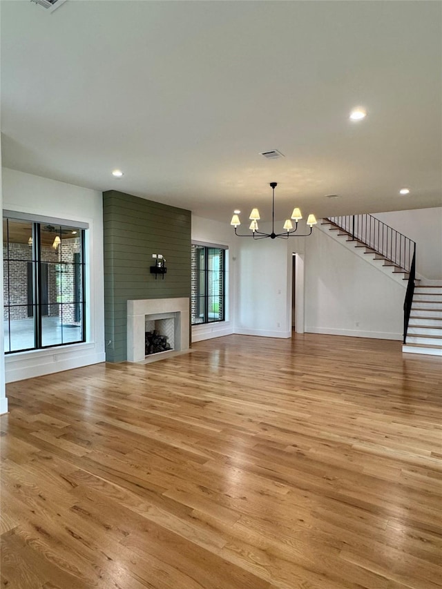 1701 Bayram Dr, Houston, TX 77055 - unfurnished living room with a chandelier, light wood-style floors, stairs, baseboards, and a fireplace