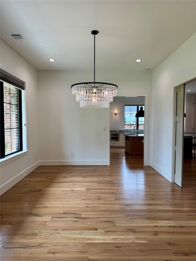 1701 Bayram Dr, Houston, TX 77055 - unfurnished dining area featuring wood finished floors, a chandelier, baseboards, and recessed lighting