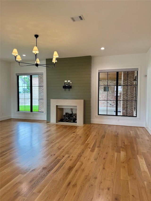 1701 Bayram Dr, Houston, TX 77055 - unfurnished living room with a chandelier, wood finished floors, a high end fireplace, baseboards, and recessed lighting