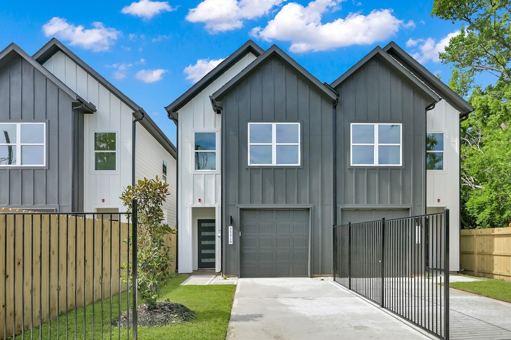 3334 Francis St, Houston, TX 77004 - view of front facade with board and batten siding, an attached garage, and driveway