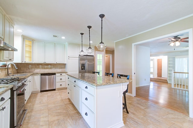 1708 Capstan Rd, Houston, TX 77062 - kitchen with appliances with stainless steel finishes, a sink, a center island, a kitchen breakfast bar, and light stone counters